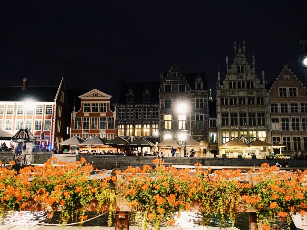 Rote Blumen dahinter die Hausreihe der Graslei in Gent