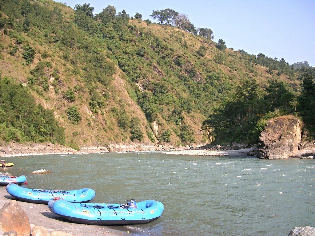 Raften am Kali Gandaki: blaue Boote liegen am Flussufer