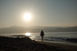 Theresa am Strand in der Bucht von Roses bei Sonnenaufgang